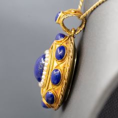 The contrast in color of this locket is exquisite, and it is impeccably made. The locket features cabochons of natural lapis lazuli, with the center cab surrounded in a frame of seed pearls. This is a picture locket with a window on the back which can be opened and a photo inserted. It features a really wide bail so that the piece can be worn over large chains or silk ribbon. The locket is crafted in 18k (x ray tested) and weighs 14.82g. It measures just under 1 3/4" in height and is just over 1" across in width. The chain is not included. Lapis And Pearl, Pearl Locket, Picture Locket, Seed Pearl, Silk Ribbon, X Ray, Lapis Lazuli, Locket, The Chain