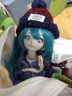 a doll with blue hair wearing a hat