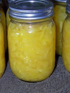 several jars filled with yellow liquid sitting on top of a counter