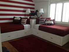 two twin beds with red and white bedding in front of an american flag wall