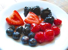 a white plate topped with berries and blueberries