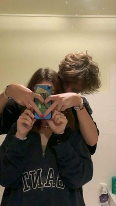 two people are taking a selfie in the mirror