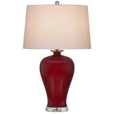 a red table lamp with a white shade