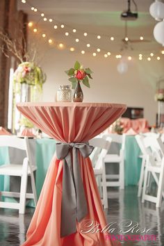 the table is decorated with pink and gray linens