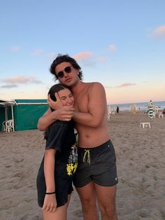 a man and woman hug on the beach