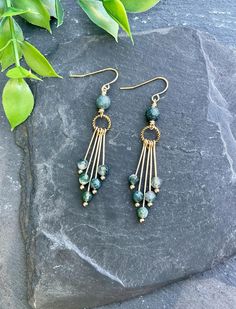 Make a statement with our Moss Agate fringe earrings! These eye-catching dangle earrings showcase natural Moss Agate gemstones hanging beautifully from a golden hoop, giving you a unique and stylish vibe. Perfect for casual outings or special events, these earrings bring a natural green charm to any outfit. EARRING FEATURES Total Length: Approximately 2.5 inches Gemstone: 6mm Round Moss Agate, 4mm Faceted Moss Agate,  Metal: Gold Tone ♥ All orders come beautifully hand-packaged with care, making it the perfect gift for yourself or someone special. ♥ Each piece is handmade with love in my home studio in Rockaway, NJ. Bohemian Agate Earrings For Pierced Ears, Beaded Agate Dangle Earrings, Agate Dangle Earrings With Ear Wire, Fringe Beaded Earrings, Moss Agate Jewelry, Green Charms, Jewelry Nature, Gold Fringe, Beaded Jewlery