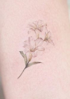 a small flower tattoo on the back of a woman's thigh