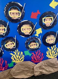 a bulletin board with pictures of people in scuba gear on it and corals around them