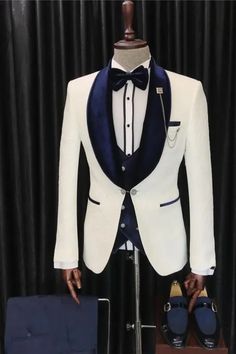 a mannequin dressed in a tuxedo and bow tie stands next to a suit case