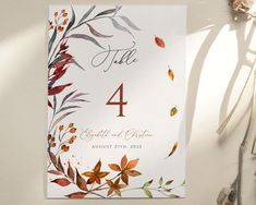 a table number card with leaves on it and the numbers 4, 4, 5, 6