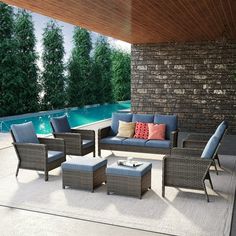 an outdoor living area with furniture and a pool in the backgroung wall