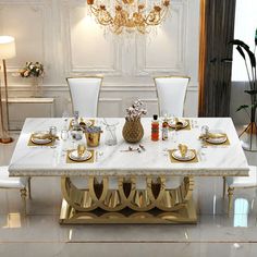 a dining room table with white chairs and gold accents