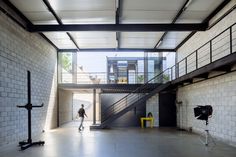 a man is walking in an empty room with white bricks on the walls and stairs