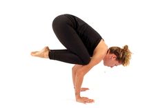 a woman is doing a yoga pose with her hands behind her head and legs bent forward