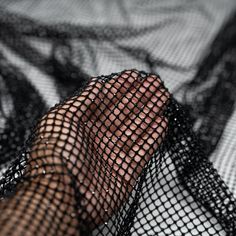 a person's hand is covered in black net