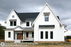 a large white house sitting on top of a lush green field