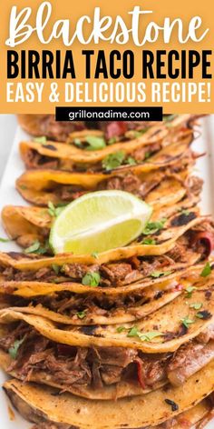 an image of shredded beef tacos on a white plate with lime and cilantro