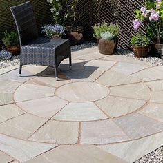 an outdoor patio with chairs and plants in the background, surrounded by graveled stones