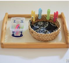 a wooden tray holding a basket with toothbrushes in it and a container on the side