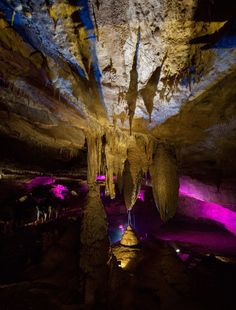 the inside of a cave with purple and blue lights