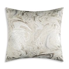 a gray and white pillow with an abstract design