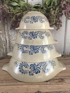 three blue and white dishes stacked on top of each other