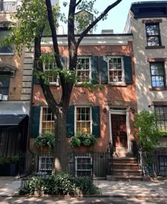 an apartment building with green shutters and trees