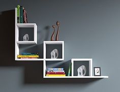 three white shelves with books and an elephant figurine on each shelf in the shape of cubes