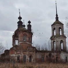 an old building with two towers and birds flying in the sky