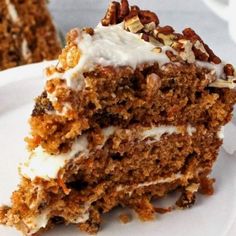 a piece of carrot cake with white frosting and pecans on the top slice