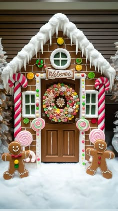 a gingerbread house decorated for christmas with candy and candies on the front door