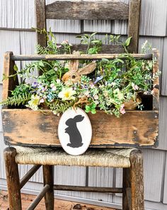 a wooden chair with a planter filled with flowers and plants on it's seat