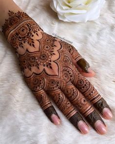 henna tattoo on the hand with flowers and petals in the background, ready to be used