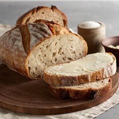 a loaf of bread sitting on top of a wooden cutting board