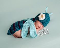 a newborn baby wearing a knitted hat with a flower