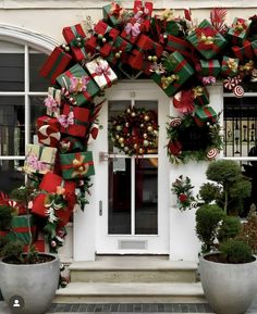 christmas wreaths and decorations on the front door of a house