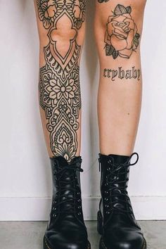 the legs and ankles of a woman with tattoos on her leg, wearing black combat boots