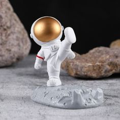 an astronaut figurine standing on top of a rock