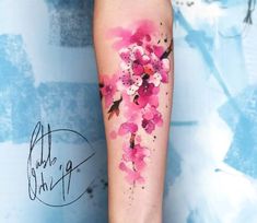 a woman's arm with pink flowers painted on it