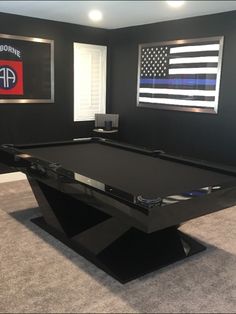 a pool table in a room with an american flag on the wall