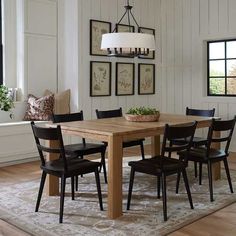 a dining room table with black chairs around it