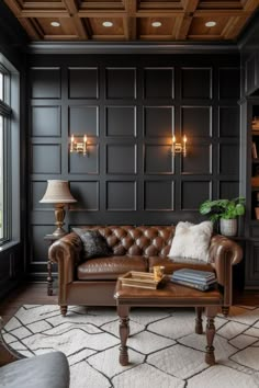 a living room with black walls and leather furniture