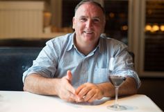 a man sitting at a table with a glass of wine