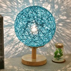 a light that is sitting on top of a table next to books and a plant