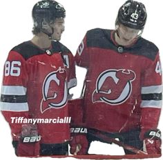 two men in red jerseys standing next to each other with their hands on their hips