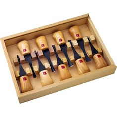 a wooden box filled with different types of knives