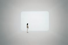 a woman standing in the middle of a white room