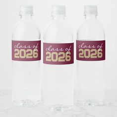 three clear water bottles with class of 205 on the front and one empty bottle in the back