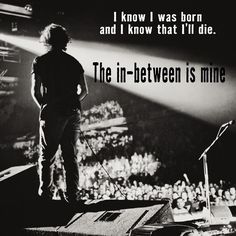 a man standing on top of a stage in front of a microphone with the words, i know i was born and i know that i'll'll die