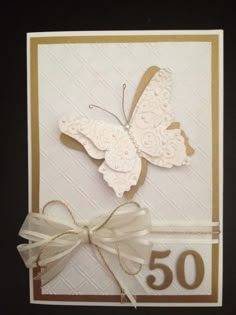 a card with a butterfly on it and the number 50 written in gold, white and brown